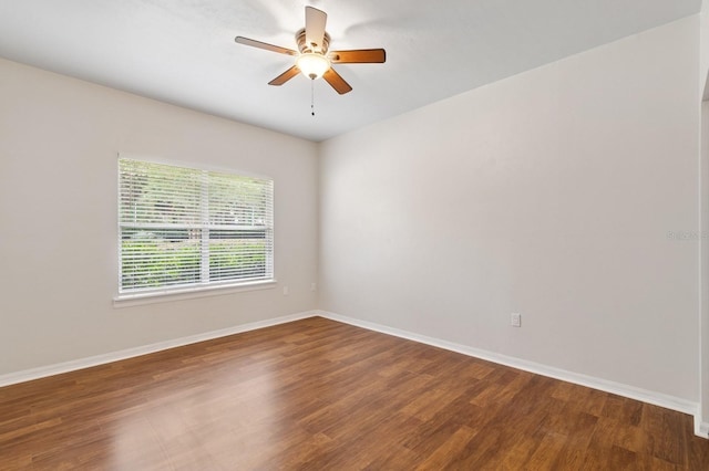 empty room with a ceiling fan, wood finished floors, and baseboards