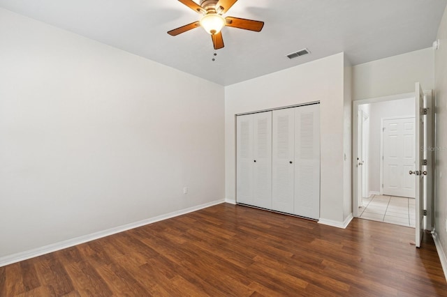 unfurnished bedroom with wood finished floors, baseboards, a closet, and ceiling fan