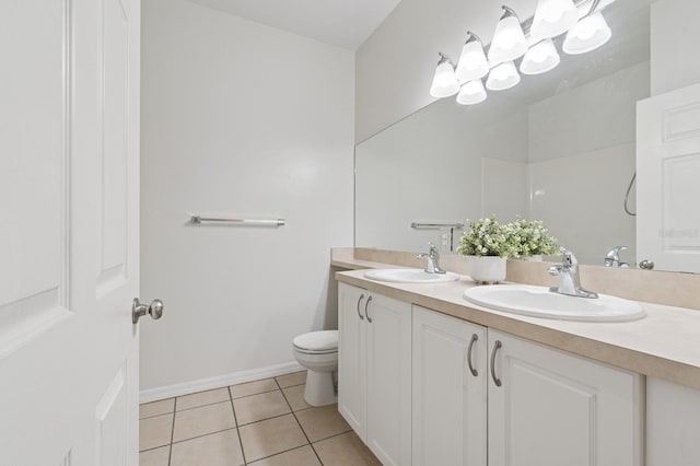bathroom featuring tile patterned flooring, double vanity, toilet, and baseboards