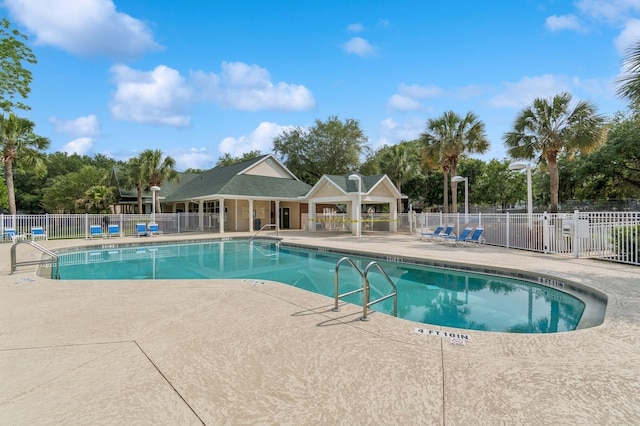 community pool with a patio area and fence