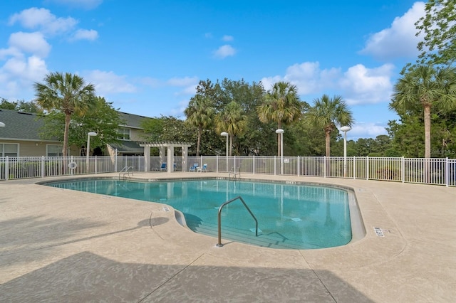 community pool featuring fence, a pergola, and a patio