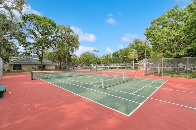 view of tennis court with fence and community basketball court