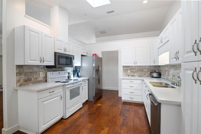 9505 NW 4th Pl, Gainesville, FL 32607 - kitchen featuring light countertops, dark wood finished floors, a sink, stainless steel appliances, and a skylight