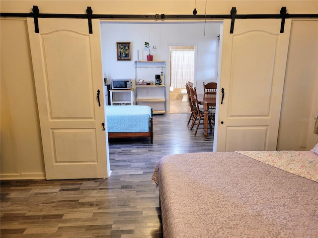 9150 SW 151st Ln, Archer, FL 32618 - bedroom with a barn door and wood finished floors