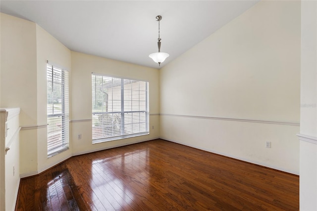 spare room with baseboards and wood-type flooring