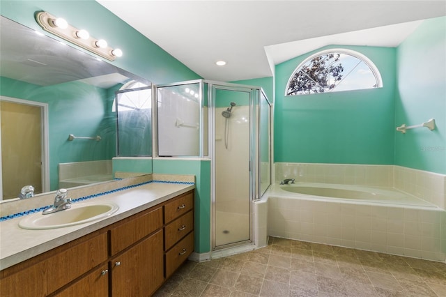 bathroom featuring a stall shower, vanity, and a garden tub