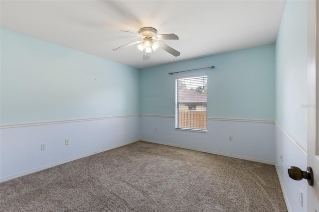 carpeted empty room featuring baseboards and a ceiling fan