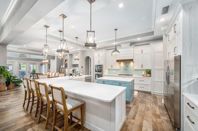 2734 SW 105th St, Gainesville, FL 32608 - kitchen featuring a spacious island, appliances with stainless steel finishes, wood-type flooring, tasteful backsplash, and recessed lighting
