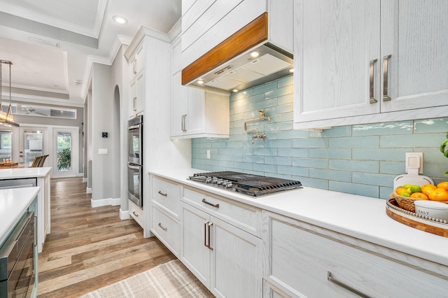 2734 SW 105th St, Gainesville, FL 32608 - kitchen with appliances with stainless steel finishes, ornamental molding, white cabinets, backsplash, and light countertops