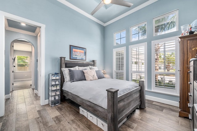 2734 SW 105th St, Gainesville, FL 32608 - bedroom featuring crown molding, arched walkways, wood finished floors, baseboards, and a ceiling fan