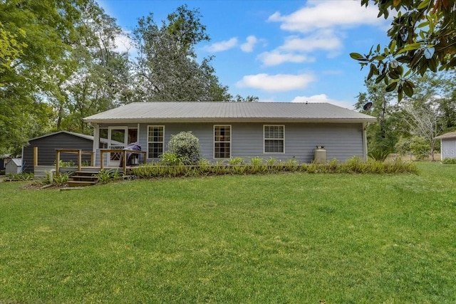 207 SW Rose Ln, Fort White, FL 32038 - rear view of house featuring a lawn, a deck, and metal roof