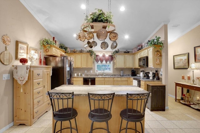 207 SW Rose Ln, Fort White, FL 32038 - kitchen featuring black appliances, light brown cabinetry, a center island, a kitchen breakfast bar, and light countertops