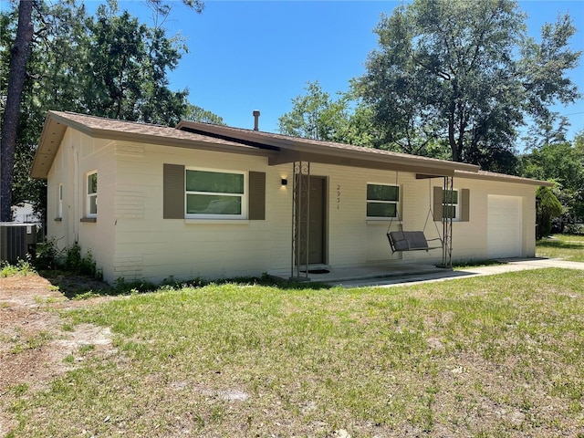 2931 NE 17th Dr, Gainesville, FL 32609 - single story home featuring a front yard, an attached garage, and central air condition unit