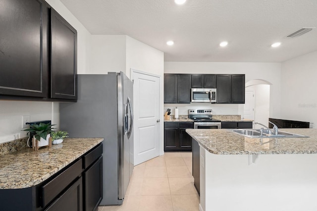 kitchen with stainless steel appliances, visible vents, arched walkways, and recessed lighting