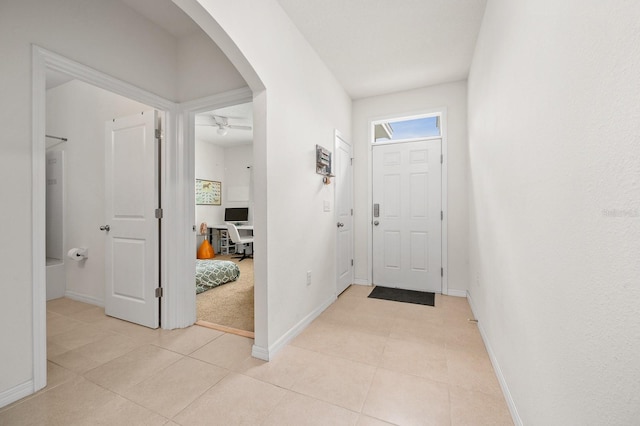 entryway featuring light tile patterned floors, baseboards, and a ceiling fan