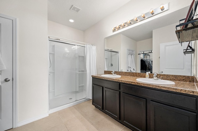 bathroom featuring a stall shower, visible vents, and a sink