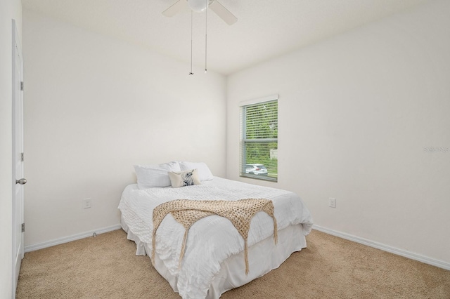 bedroom with light colored carpet, baseboards, and ceiling fan