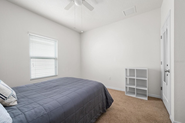 carpeted bedroom with baseboards, a ceiling fan, and visible vents