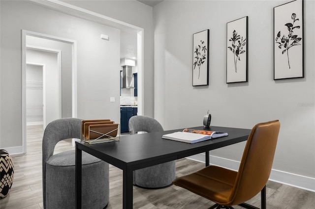 dining space with wood finished floors, baseboards, and an office area