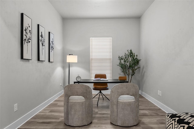 home office with baseboards and wood finished floors
