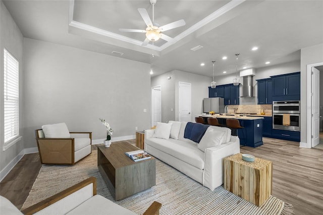 living room featuring light wood-style floors, healthy amount of natural light, ceiling fan, recessed lighting, and ornamental molding