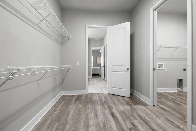 walk in closet with wood finished floors