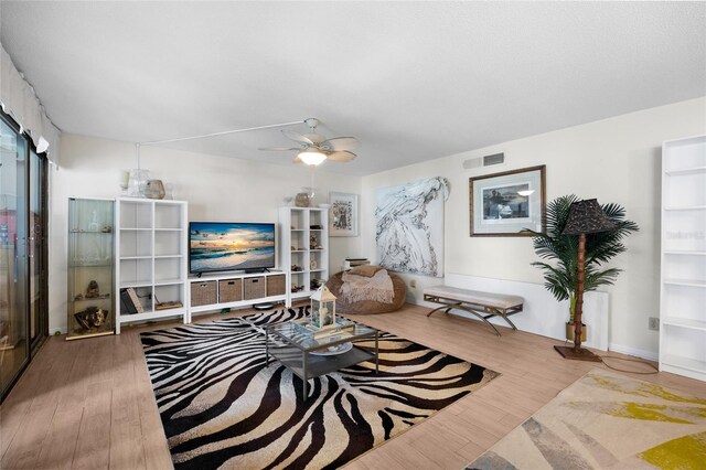 living room with wood finished floors and ceiling fan