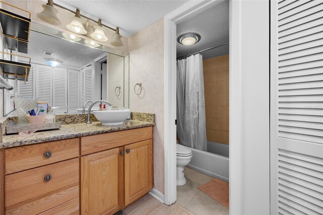 full bath featuring a textured ceiling, toilet, vanity, tile patterned floors, and shower / bath combo with shower curtain