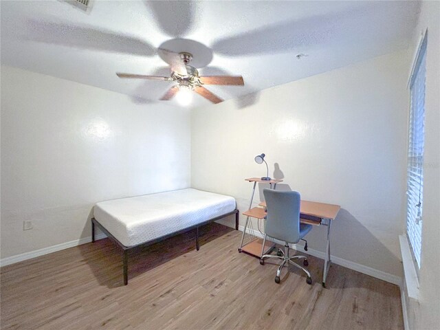 4000 SW 23rd St Unit 3-107, Gainesville, FL 32608 - home office with wood finished floors, a ceiling fan, and baseboards