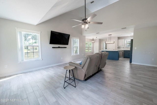 11802 SW 83rd Dr, Lake Butler, FL 32054 - living room featuring lofted ceiling, light wood-type flooring, plenty of natural light, and ceiling fan with notable chandelier