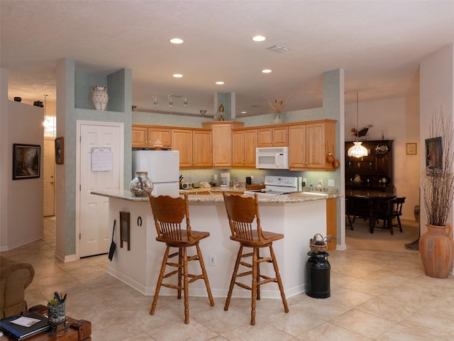 10712 SW 12th Ter, Micanopy, FL 32667 - kitchen featuring white appliances, recessed lighting, a center island, light stone counters, and light tile patterned flooring
