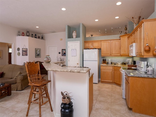 10712 SW 12th Ter, Micanopy, FL 32667 - kitchen featuring white appliances, recessed lighting, a kitchen bar, light stone countertops, and light tile patterned floors
