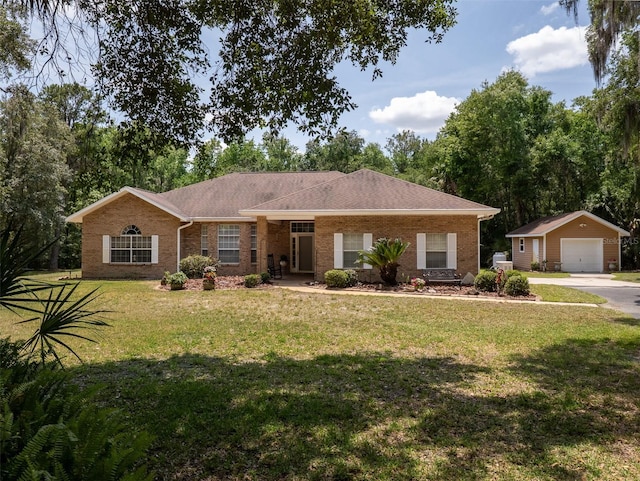 10712 SW 12th Ter, Micanopy, FL 32667 - single story home with an outbuilding, a detached garage, brick siding, a front lawn, and driveway