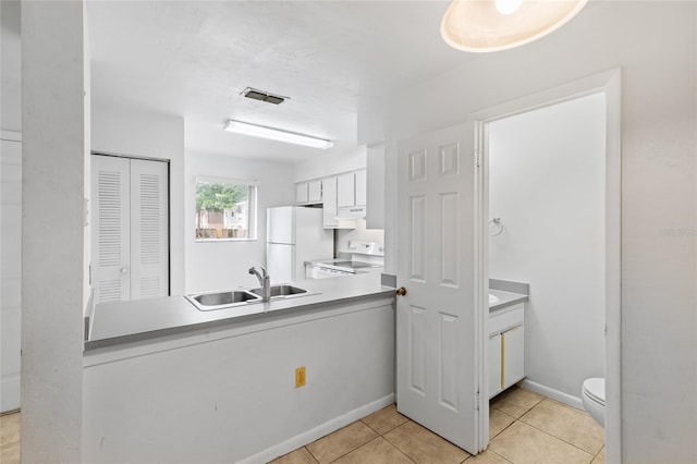 2219 SW 39th Way, Gainesville, FL 32607 - kitchen with a sink, white appliances, white cabinetry, light tile patterned flooring, and a peninsula
