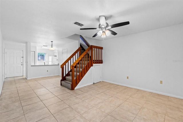 2219 SW 39th Way, Gainesville, FL 32607 - unfurnished living room with ceiling fan, stairway, light tile patterned flooring, and baseboards