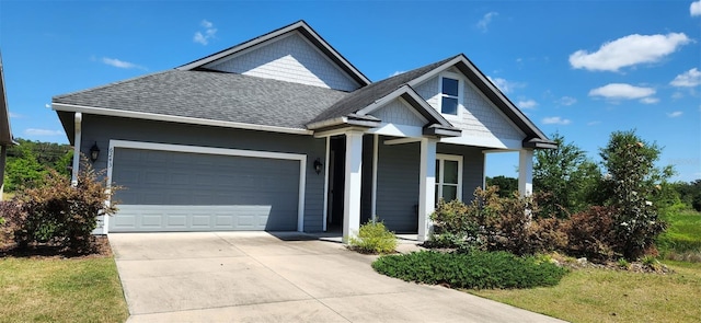 view of front of home with a garage, a shingled roof, concrete driveway, and a porch