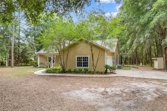 view of property exterior featuring driveway and cooling unit