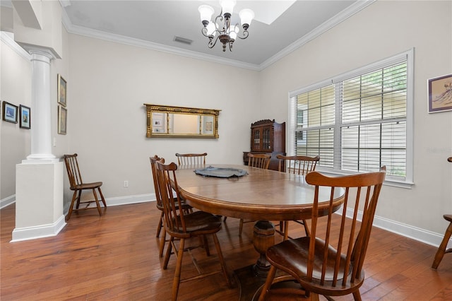 dining space featuring decorative columns, wood finished floors, plenty of natural light, and ornamental molding