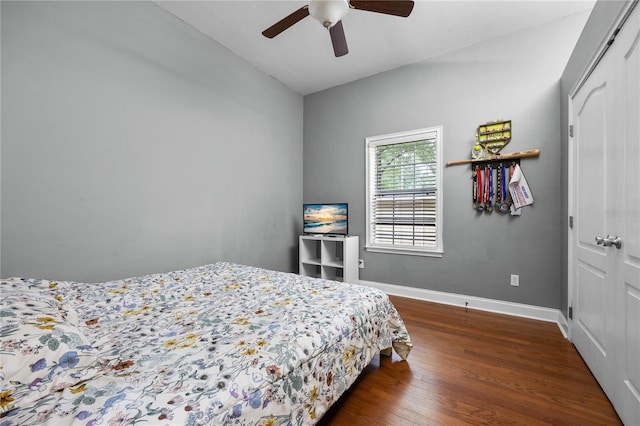 bedroom featuring wood finished floors, baseboards, a closet, a ceiling fan, and lofted ceiling