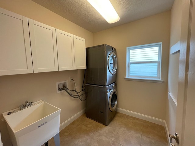 8216 NW 54th St, Gainesville, FL 32653 - laundry area with stacked washer / drying machine, cabinet space, a textured ceiling, baseboards, and light tile patterned flooring