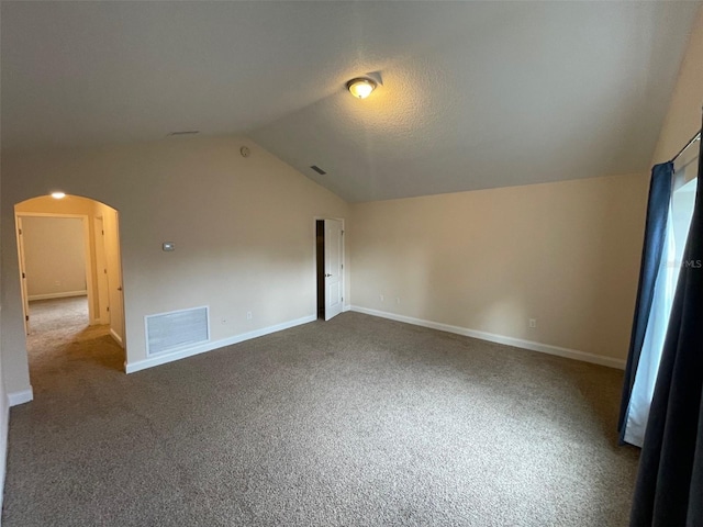 8216 NW 54th St, Gainesville, FL 32653 - additional living space featuring vaulted ceiling, arched walkways, carpet flooring, and baseboards