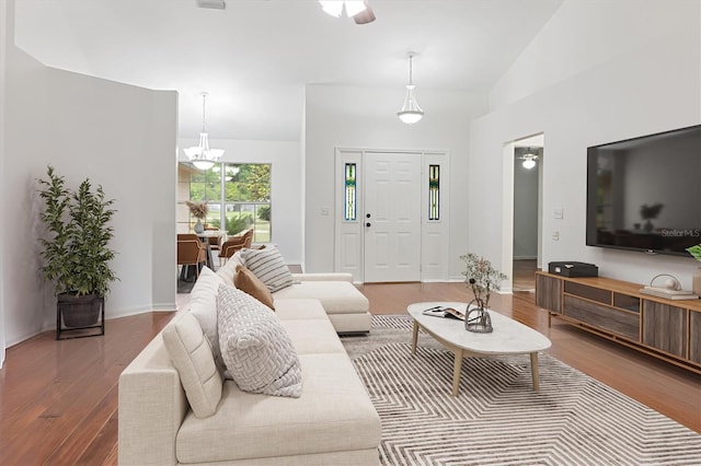 living area featuring wood finished floors, a chandelier, and vaulted ceiling