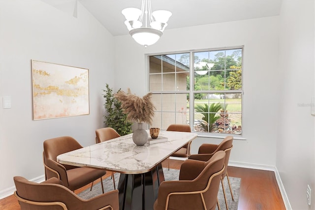 dining area with wood finished floors, a chandelier, and baseboards