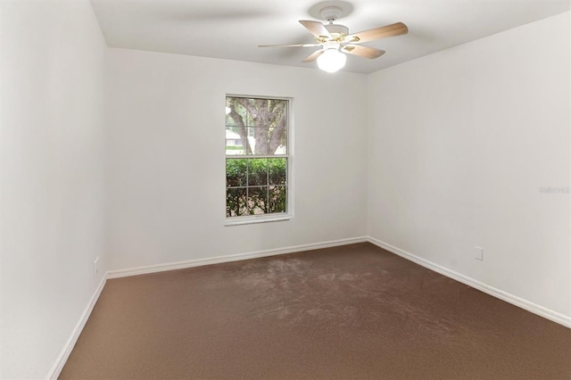 unfurnished room featuring ceiling fan, dark colored carpet, and baseboards