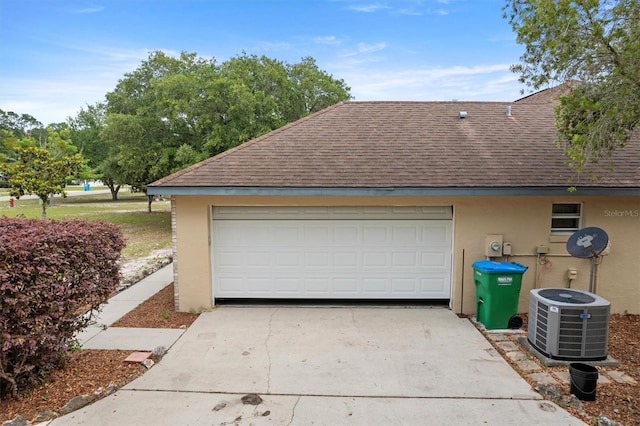 garage featuring central AC unit and driveway
