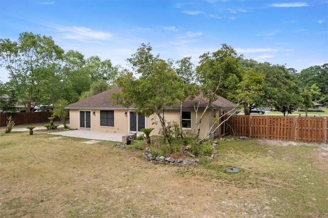 back of property with stucco siding, a patio area, and roof with shingles