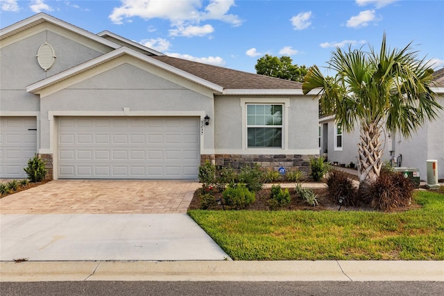 5237 NW 48th Pl, Ocala, FL 34482 - ranch-style home featuring stone siding, decorative driveway, stucco siding, and an attached garage
