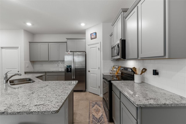 5237 NW 48th Pl, Ocala, FL 34482 - kitchen featuring stainless steel appliances, gray cabinetry, backsplash, light stone counters, and recessed lighting