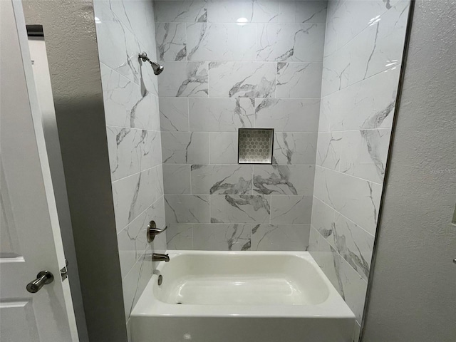 634 NE 15th Ter, Gainesville, FL 32641 - bathroom featuring shower / bath combination and a textured wall