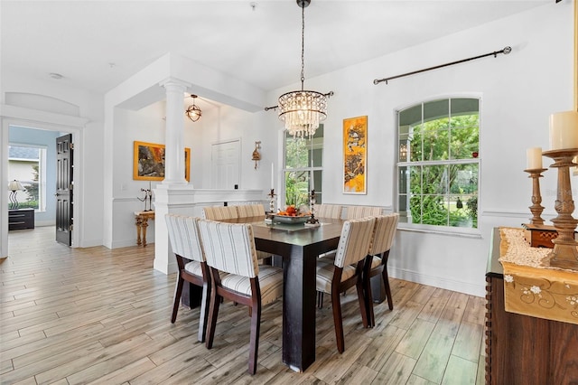 23510 Oak Prairie Cir, Sorrento, FL 32776 - dining space featuring light wood-type flooring, decorative columns, a chandelier, and baseboards